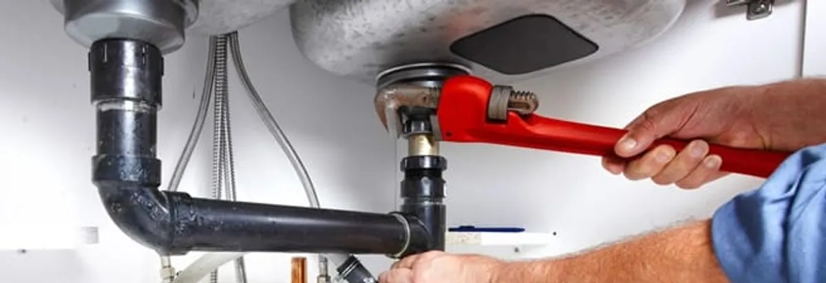Garbage disposal repair technician tightening the sink drain and disposal connection in Naperville, IL